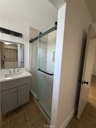 a bathroom with a shower sink and mirror