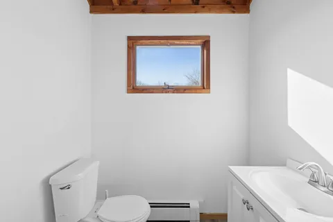 a bathroom with a toilet sink vanity and mirror
