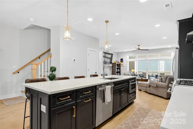 a kitchen with a stove a sink a kitchen island with wooden cabinets and couches