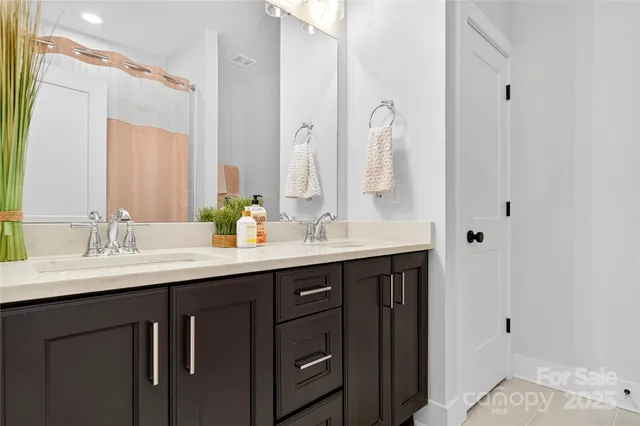 a bathroom with a double vanity sink and a mirror