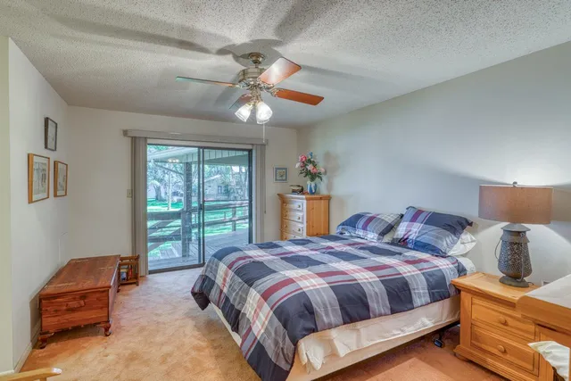 a view of a white house with a big yard and large trees