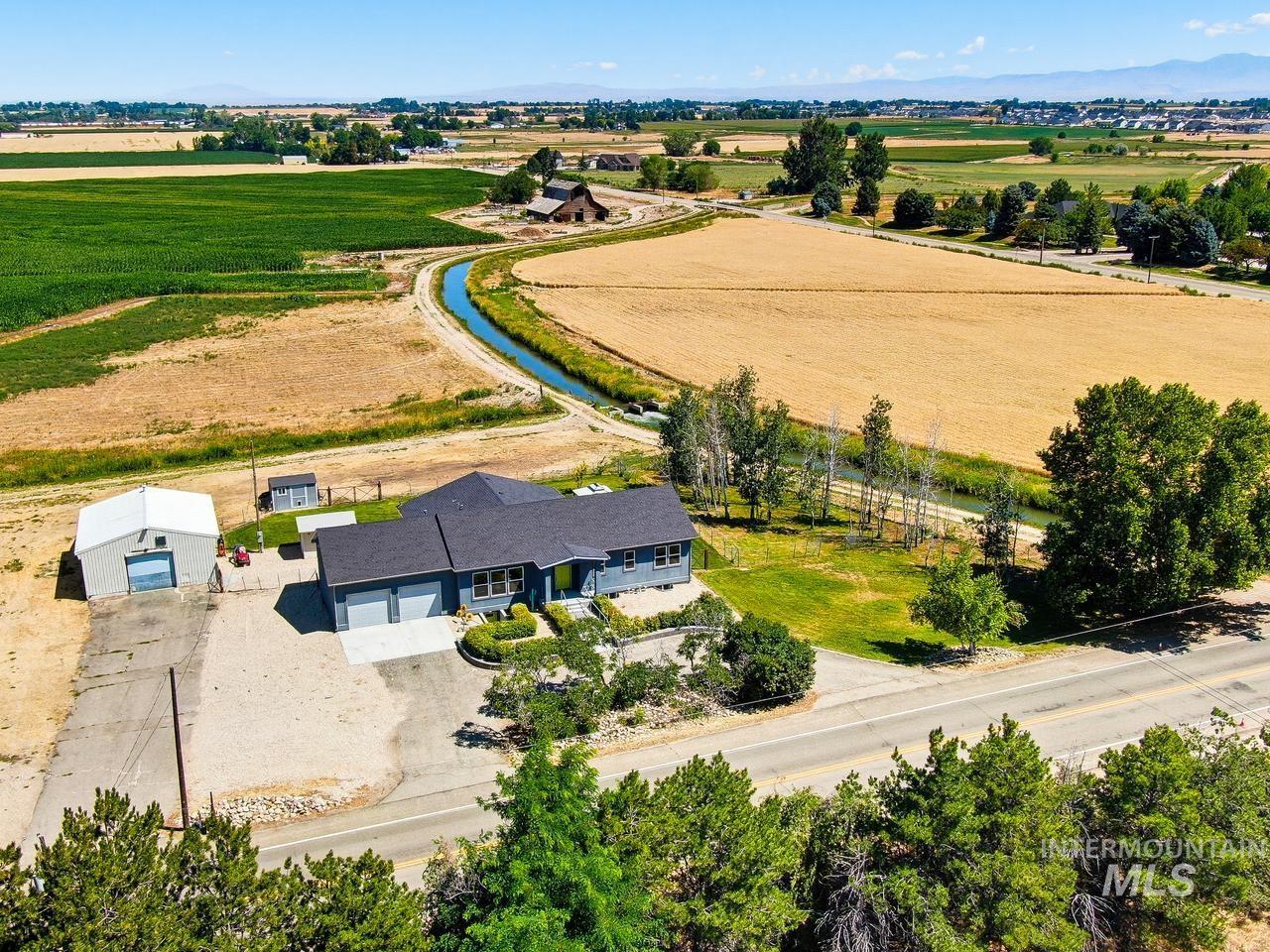 4950 West Columbia Road Nampa, ID 83687 - Photo 1 of 50 Contemporary ranch-style residence featuring a dark roof and light blue siding