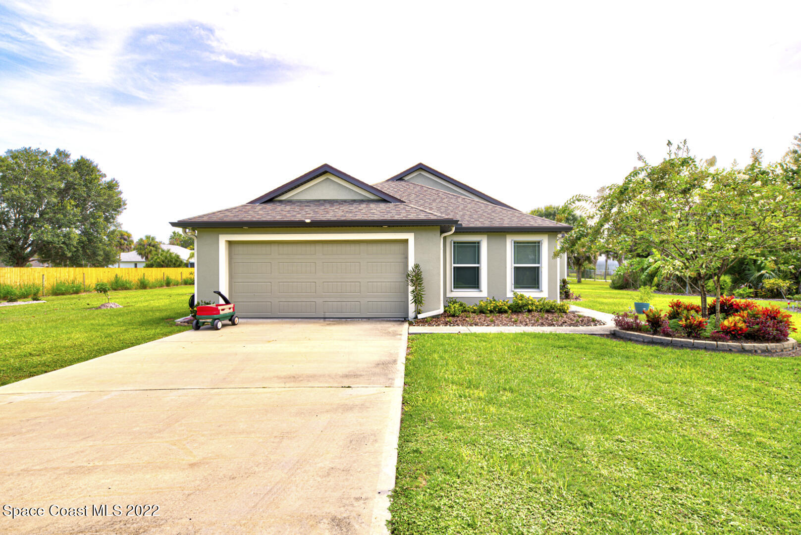 3945 Post Road Melbourne, FL 32934 - Photo 1 of 24 a front view of a house with a yard and garage