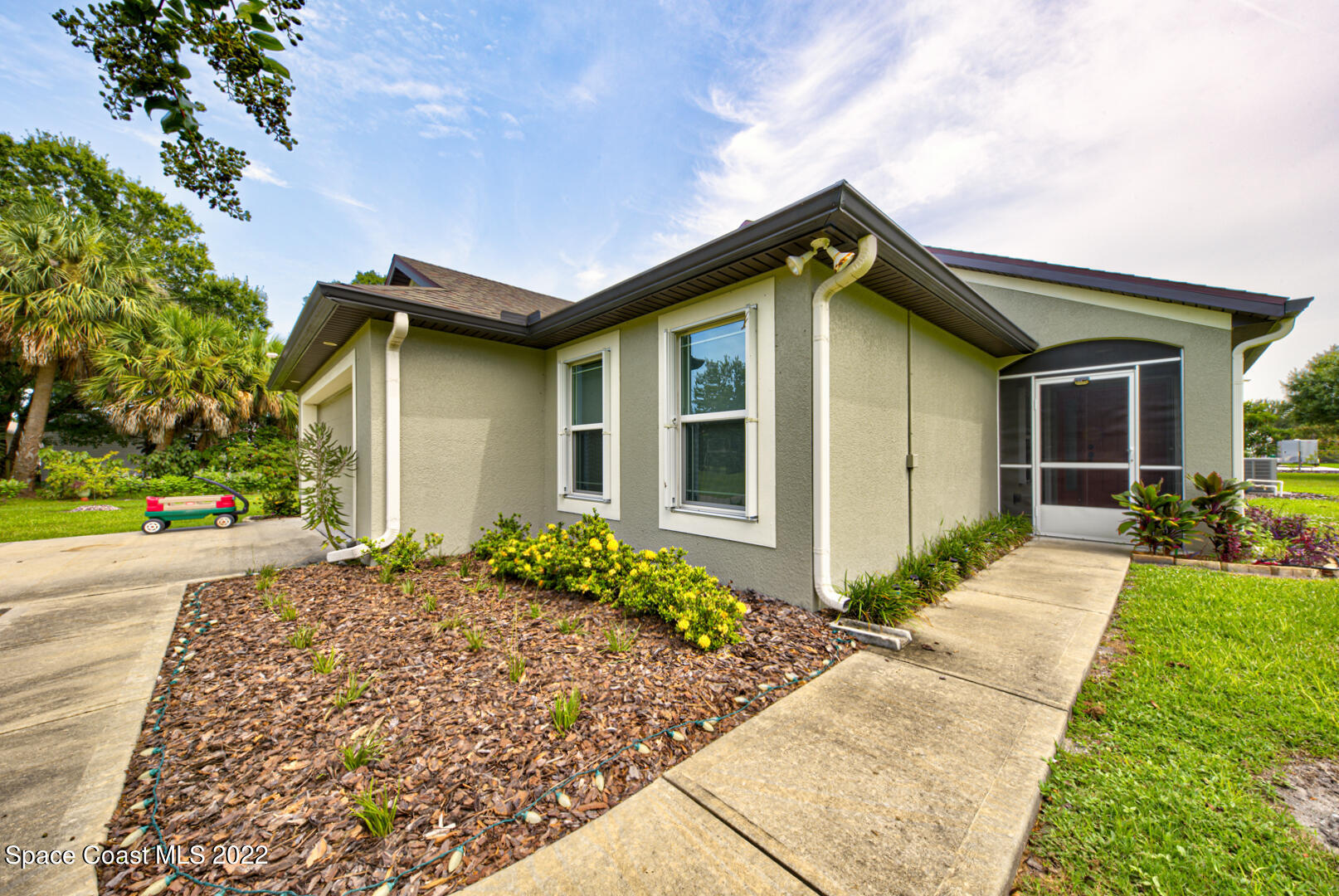 3945 Post Road Melbourne, FL 32934 - Photo 4 of 24 a front view of a house with a yard and potted plants
