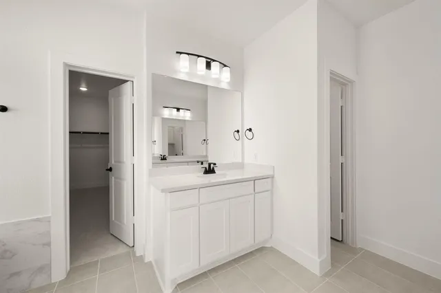 a spacious bathroom with a double vanity sink and mirror
