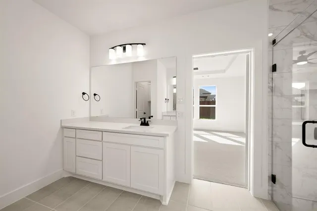 a spacious bathroom with a shower a sink and a mirror