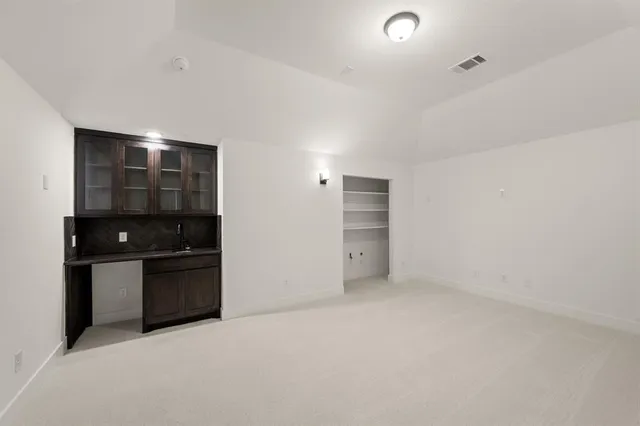 a view of an empty room with kitchen