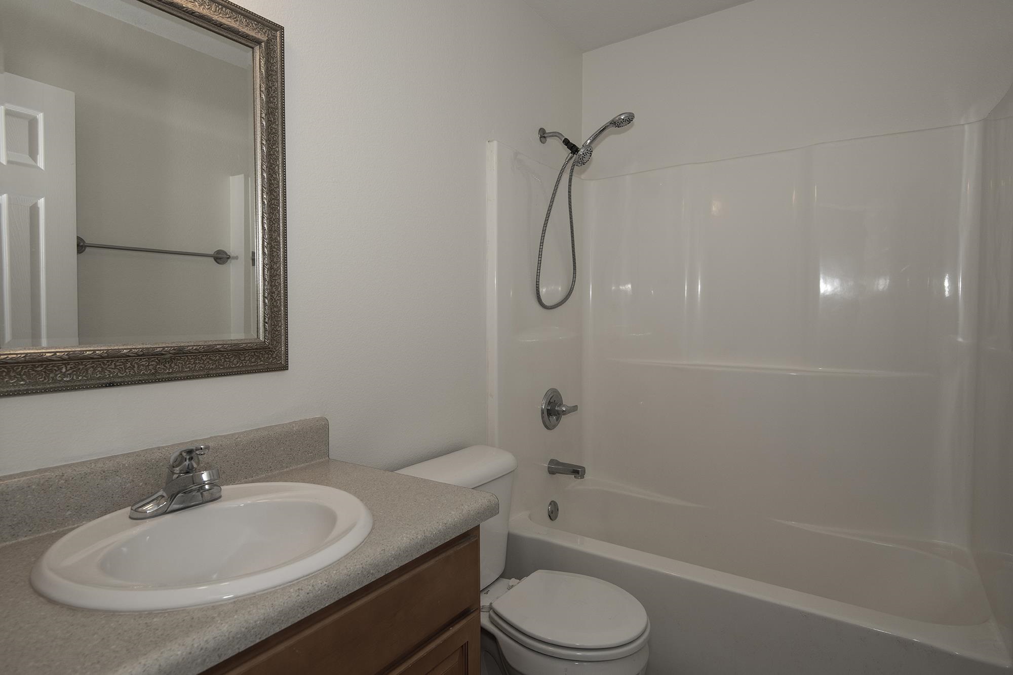 4608 Anna Simpson Road Milton, FL 32583 - Photo 16 of 22 a bathroom with a granite countertop sink a toilet and shower