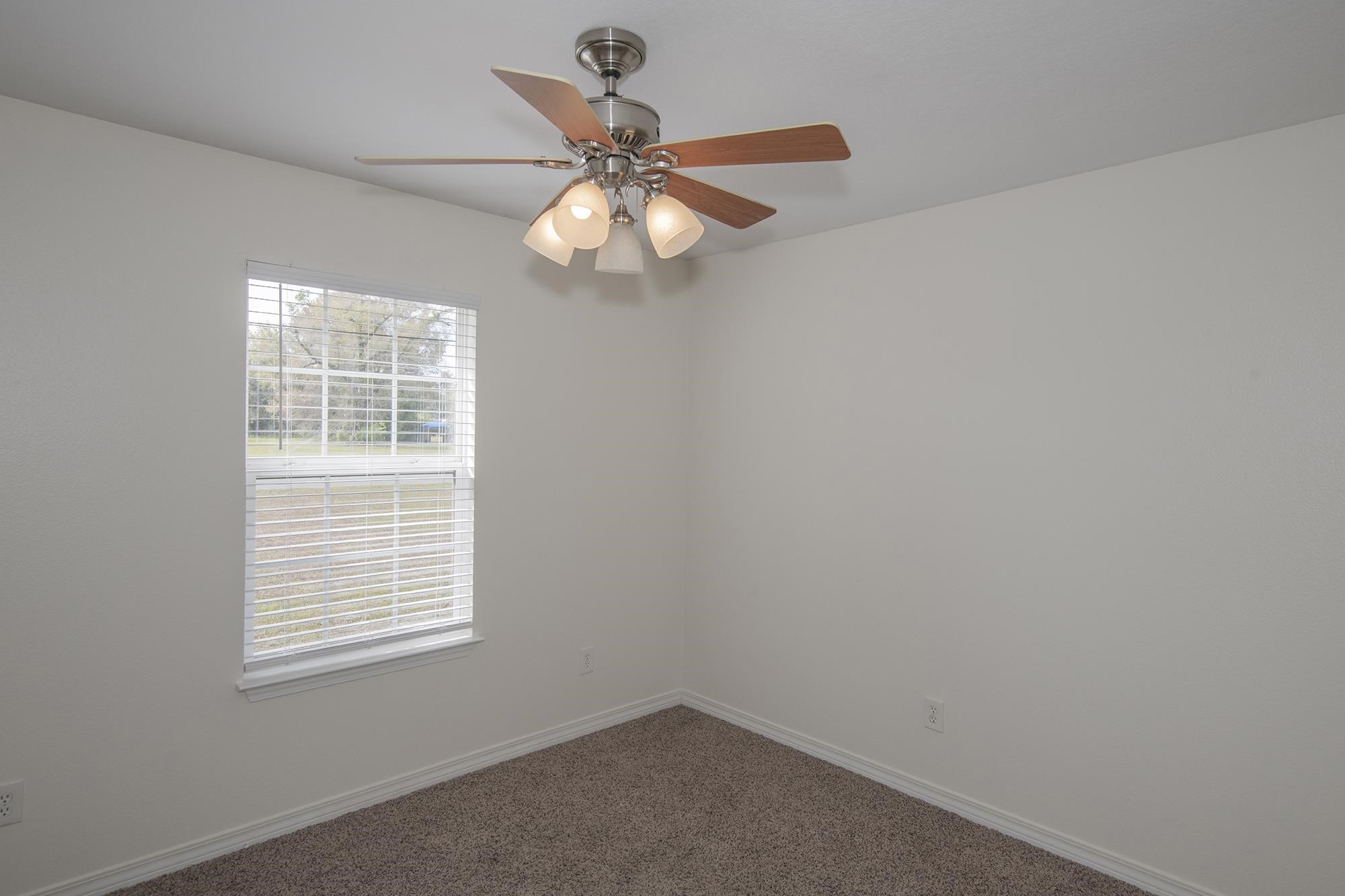 4608 Anna Simpson Road Milton, FL 32583 - Photo 17 of 22 an empty room with windows and fan