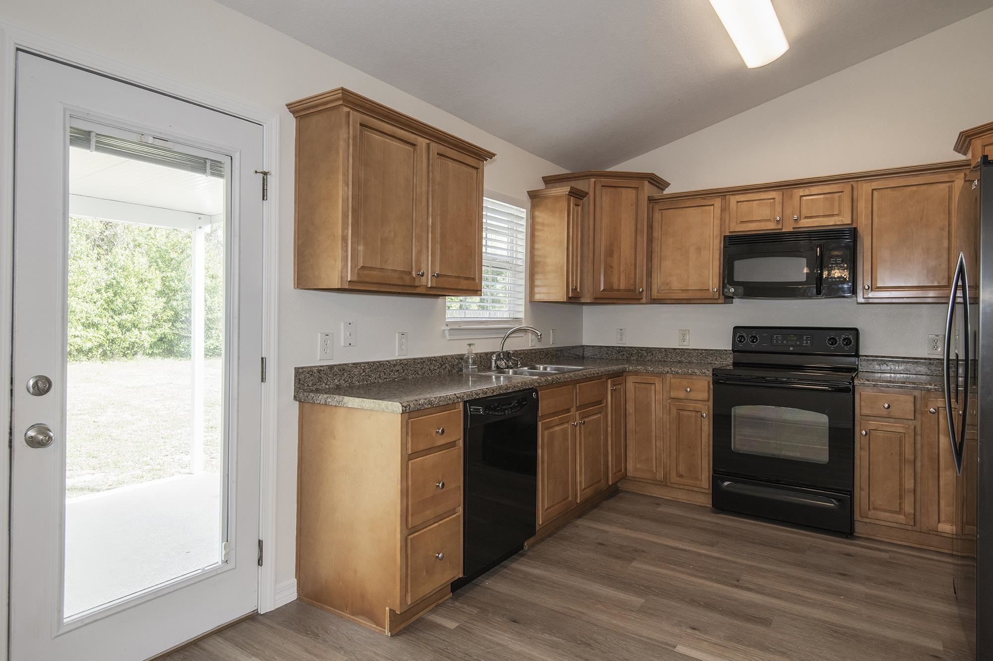 4608 Anna Simpson Road Milton, FL 32583 - Photo 9 of 22 a kitchen with stainless steel appliances granite countertop a stove a sink and a microwave