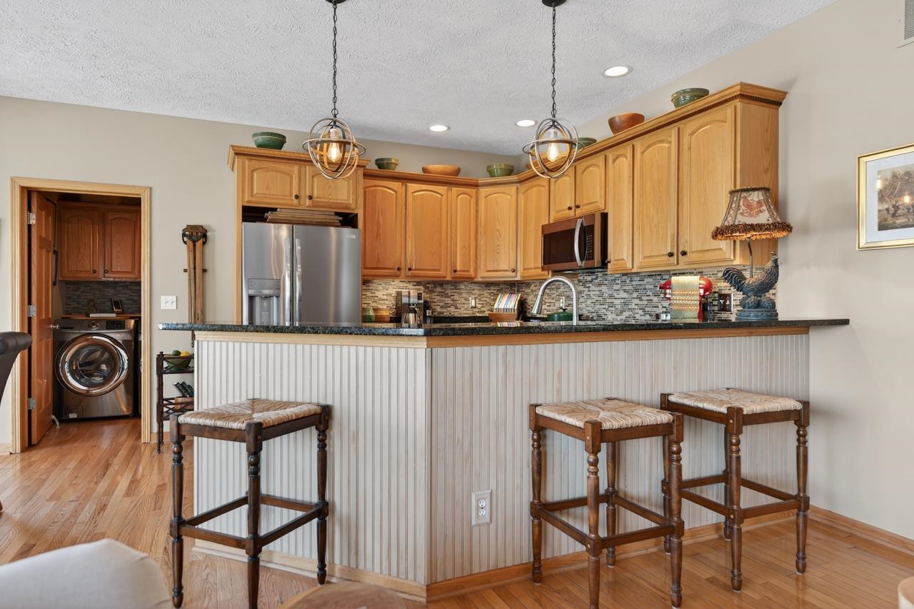 12805 Edgewater Pointe Winnebago, IL 61088 - Photo 14 of 47 a kitchen with a table chairs refrigerator and microwave