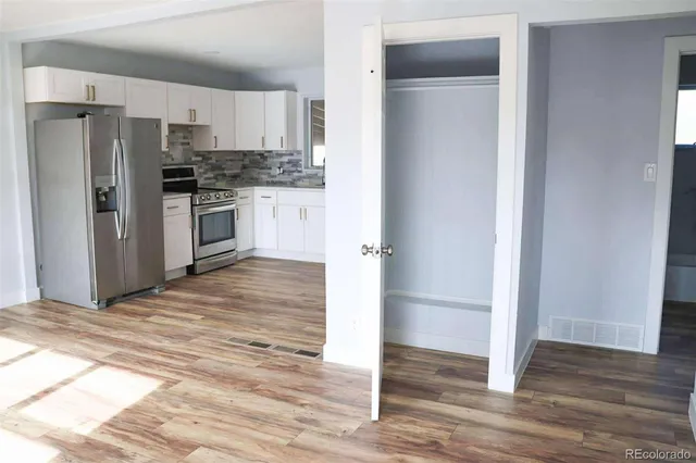 a kitchen with granite countertop a refrigerator and a stove top oven