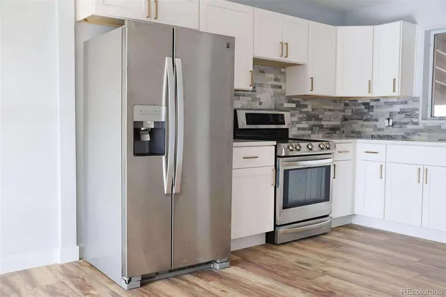 a kitchen with stainless steel appliances a refrigerator stove and cabinets