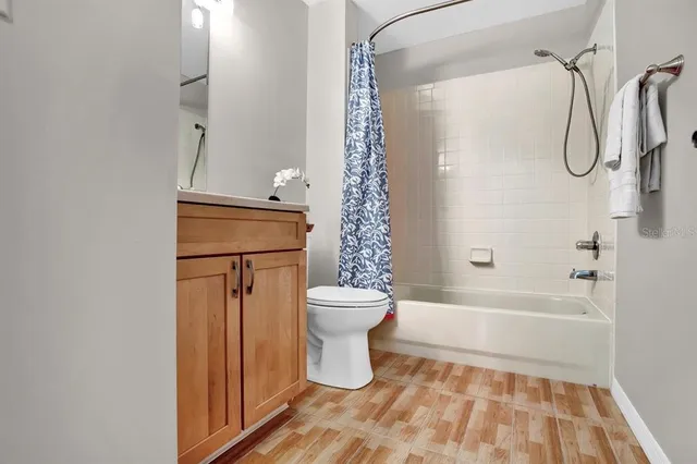a bathroom with a bathtub shower sink vanity and toilet