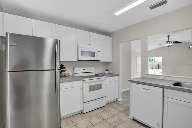 a kitchen with cabinets stainless steel appliances and a window