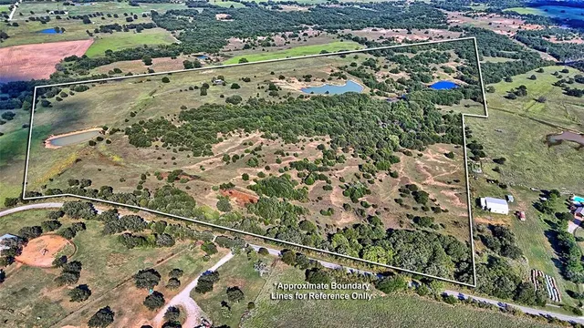 an aerial view of residential houses with outdoor space and trees