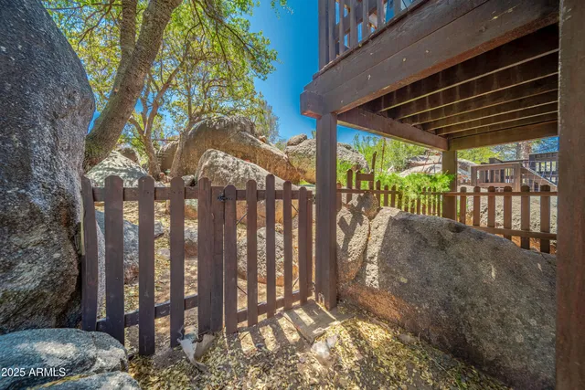 a view of a backyard with floor to ceiling window and wooden fence