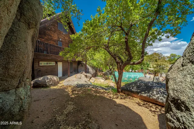 an aerial view of residential houses with outdoor space and trees