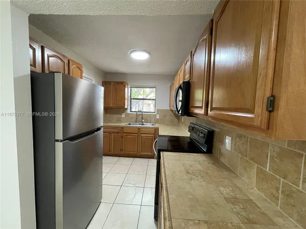 a kitchen with a sink a stove and a refrigerator
