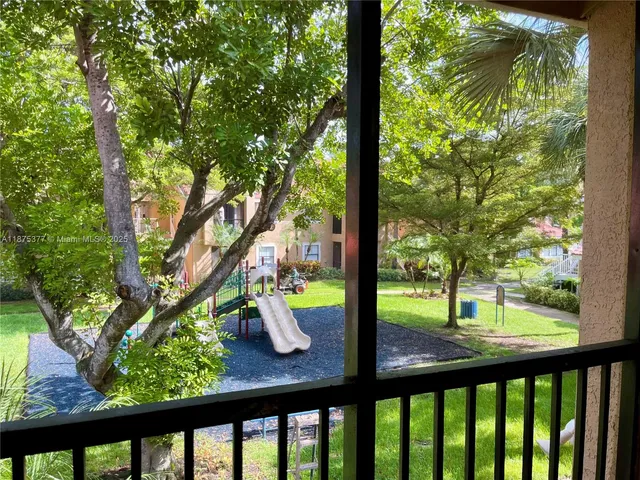 a view of trees and deck in the outdoor space