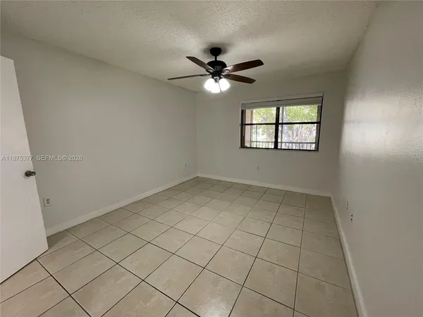 an empty room with closet and a chandelier fan