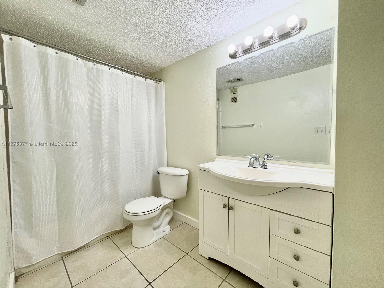 15591 Southwest 105th Terrace, Unit 527 Miami, FL 33196 - Photo 18 of 24 a bathroom with a toilet sink and mirror