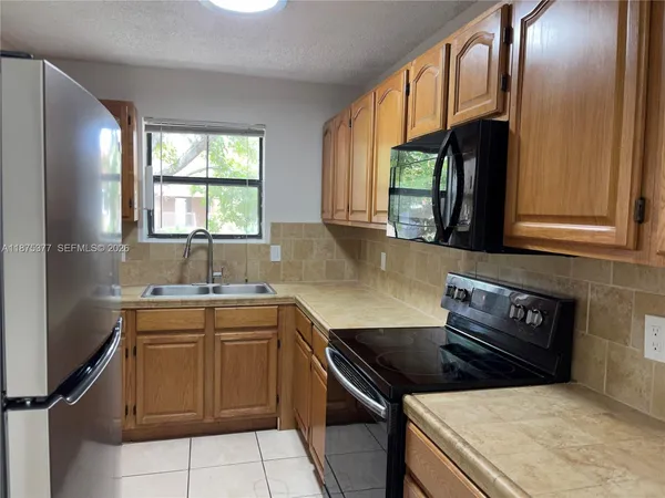 a kitchen with a stove a sink and a window