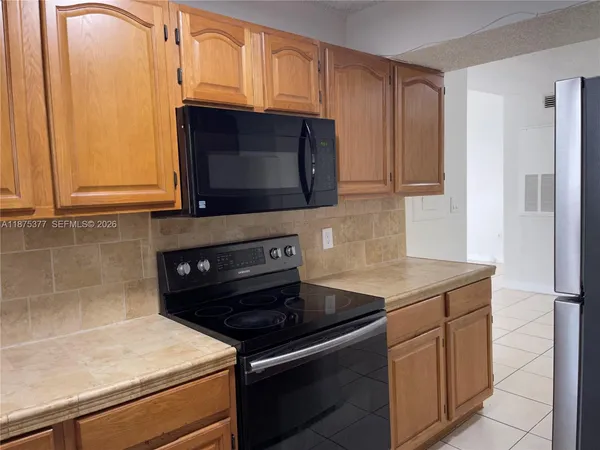 a kitchen with stainless steel appliances granite countertop a sink stove and microwave