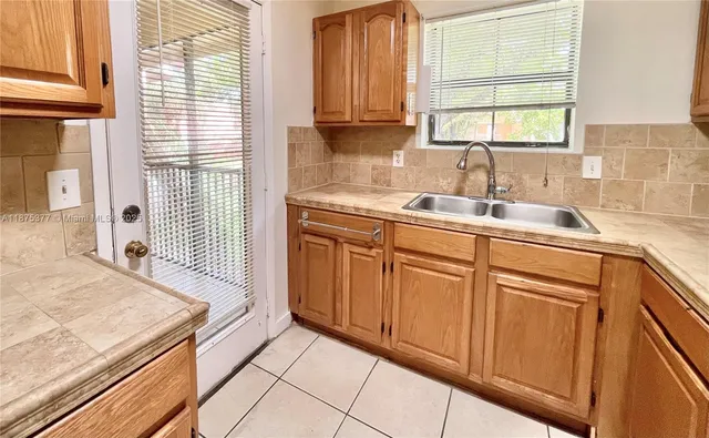 a kitchen with granite countertop white cabinets and sink