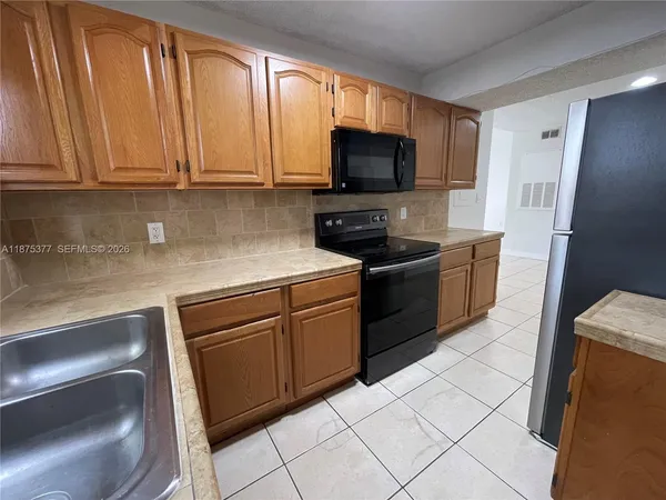 a kitchen with stainless steel appliances granite countertop a sink and a microwave