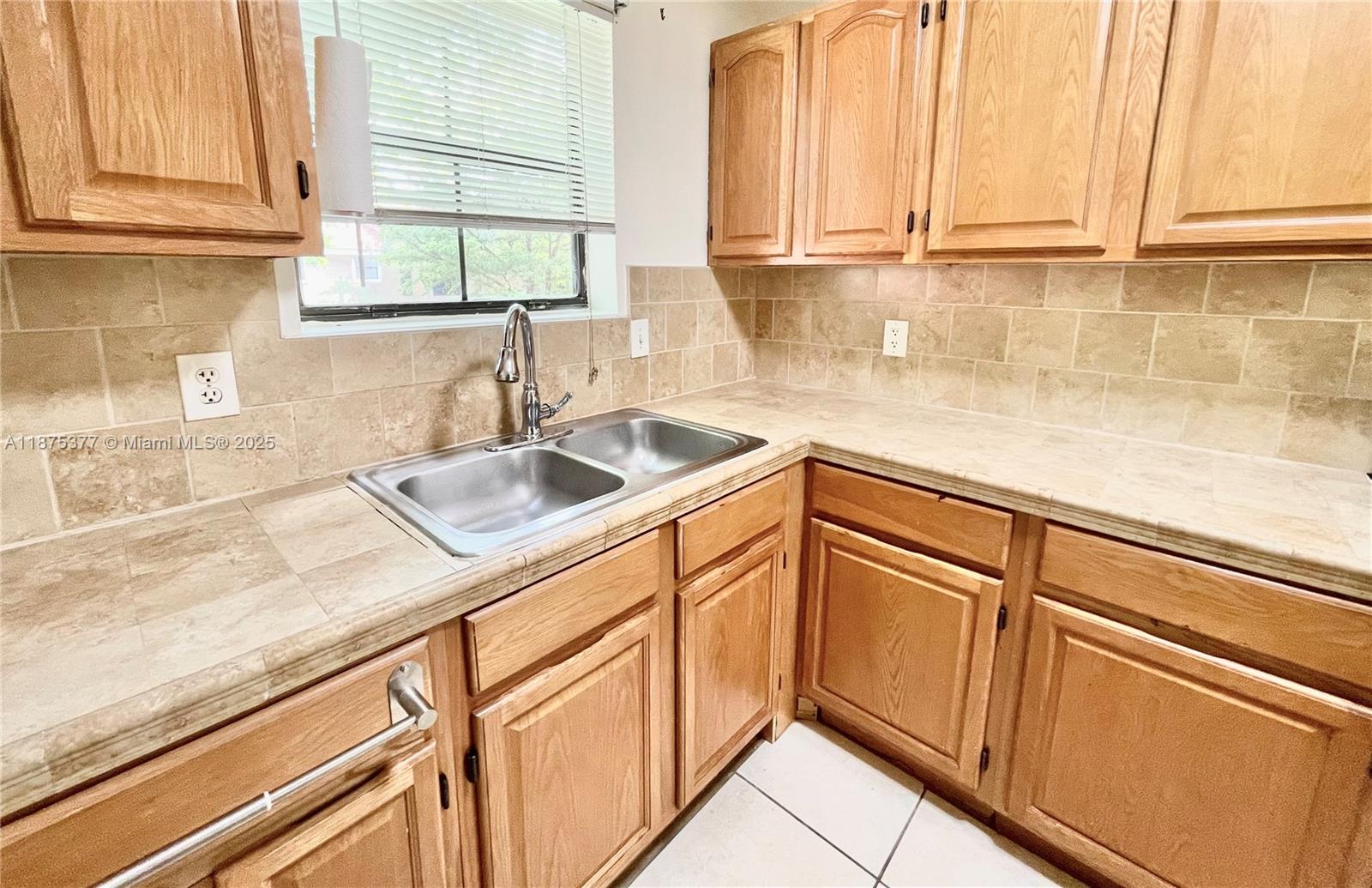 15591 Southwest 105th Terrace, Unit 527 Miami, FL 33196 - Photo 10 of 24 a kitchen with granite countertop a sink and a window