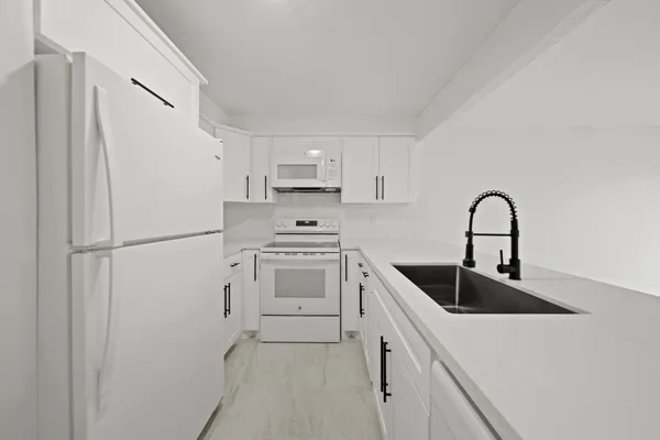 a kitchen with a refrigerator sink and cabinets