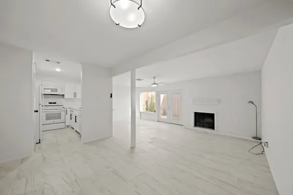 a view of an empty room with a fireplace and a window