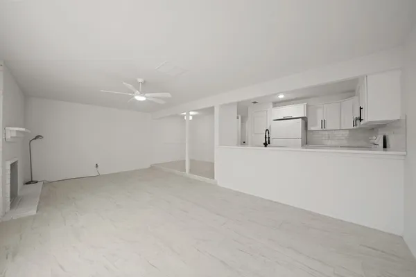 an empty room with windows and ceiling fan