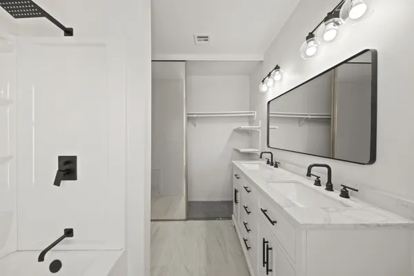 a bathroom with a sink vanity granite toilet and a mirror