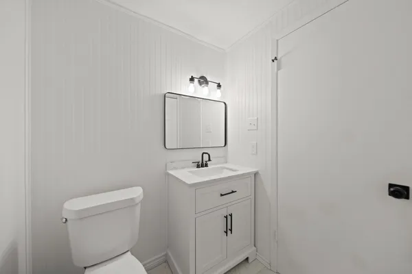 a bathroom with a sink toilet and mirror