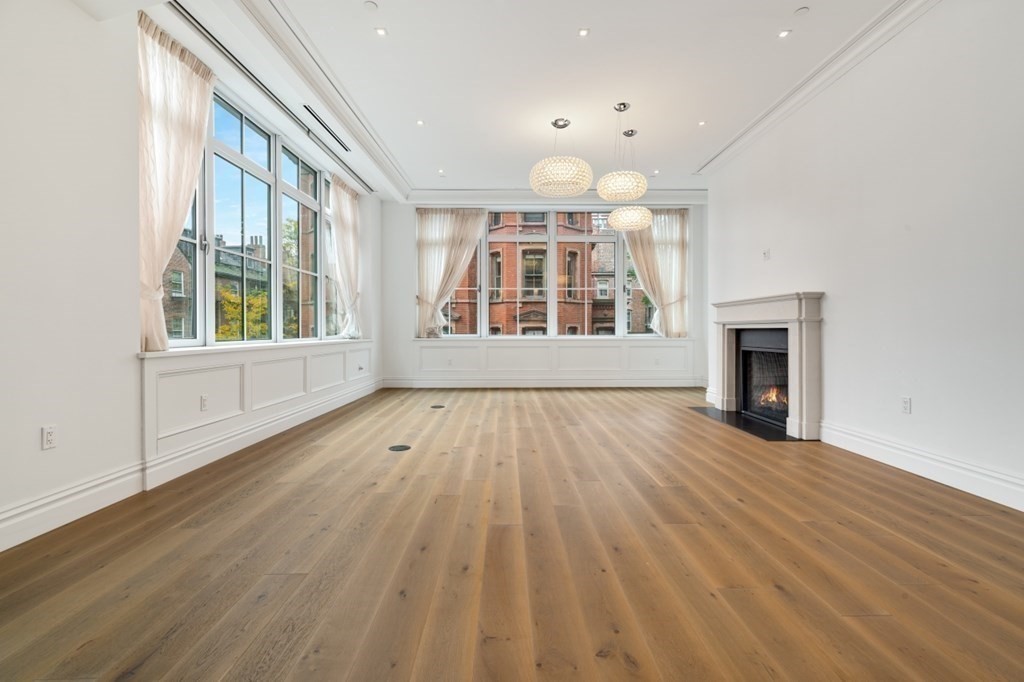 32 Derne Street, Unit 3A Boston, MA 02114 - Photo 13 of 25 a view of an empty room with wooden floor and a window