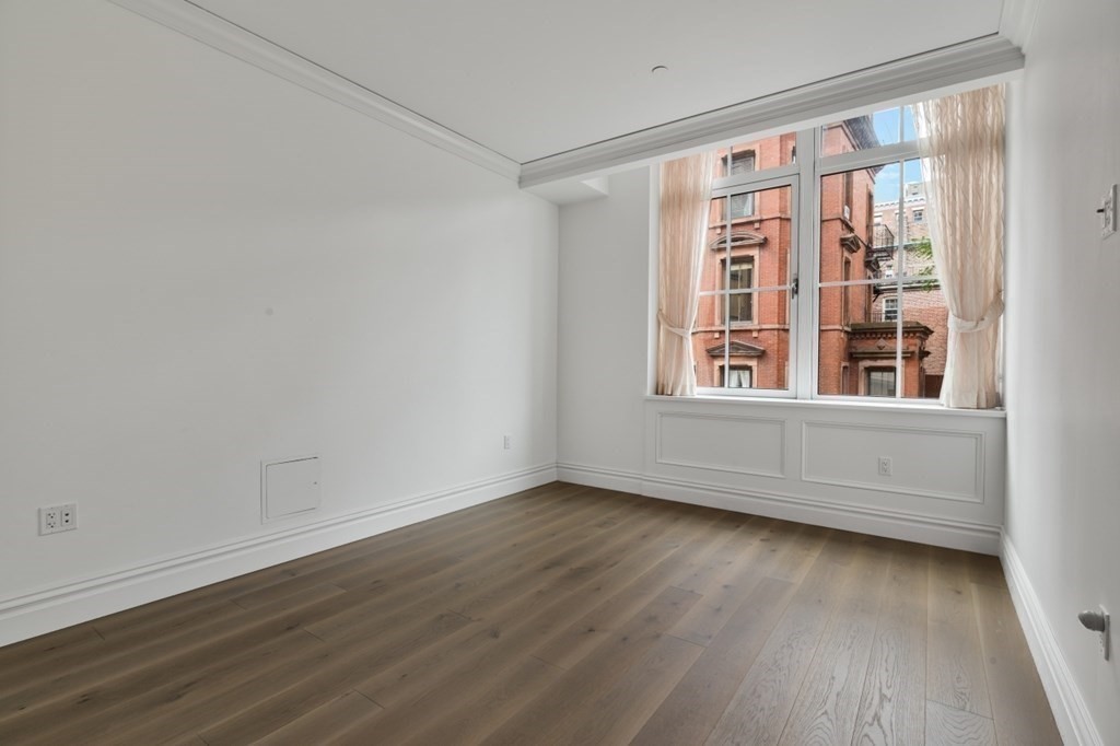 32 Derne Street, Unit 3A Boston, MA 02114 - Photo 14 of 25 a view of an empty room with wooden floor and a window