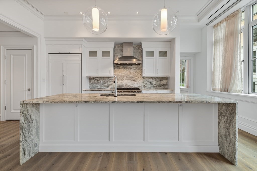 32 Derne Street, Unit 3A Boston, MA 02114 - Photo 4 of 25 a kitchen with kitchen island granite countertop a sink and cabinets