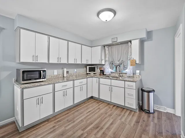 a kitchen with granite countertop white cabinets and white appliances