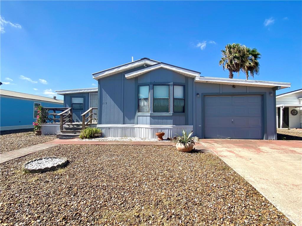 View of front of house with driveway, a garage, and a porch