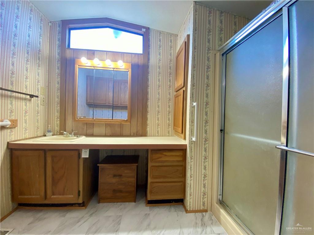 219 Bundle Wagon Drive Mission, TX 78574 - Photo 11 of 30 Full bathroom with wallpapered walls, vanity, a shower stall, and lofted ceiling