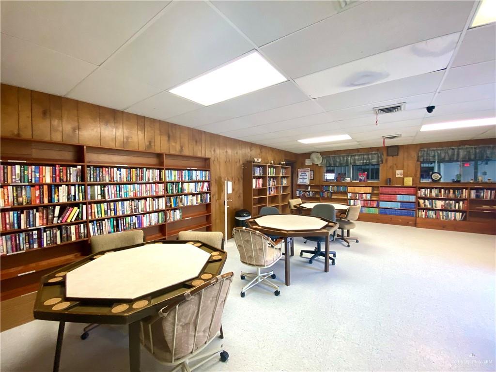 219 Bundle Wagon Drive Mission, TX 78574 - Photo 25 of 30 Home office featuring wall of books, wood walls, and a paneled ceiling