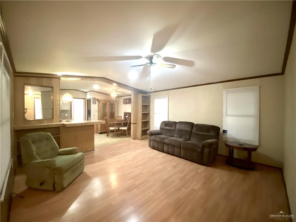 219 Bundle Wagon Drive Mission, TX 78574 - Photo 3 of 30 Living area featuring ceiling fan, light wood finished floors, and ornamental molding