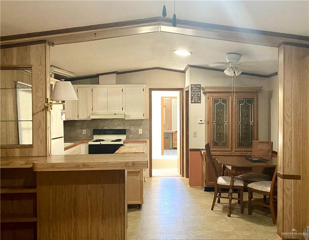 219 Bundle Wagon Drive Mission, TX 78574 - Photo 5 of 30 Kitchen with vaulted ceiling, white electric range oven, light floors, a ceiling fan, and crown molding