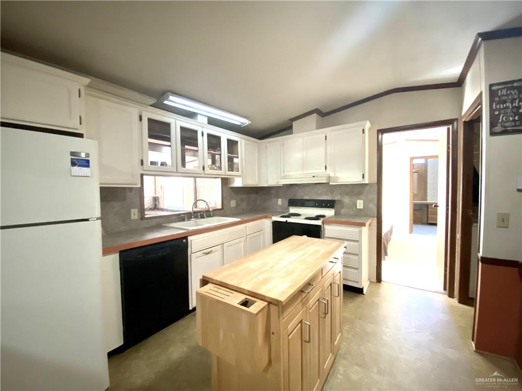 219 Bundle Wagon Drive Mission, TX 78574 - Photo 7 of 30 Kitchen featuring butcher block countertops, white appliances, vaulted ceiling, ornamental molding, and tasteful backsplash
