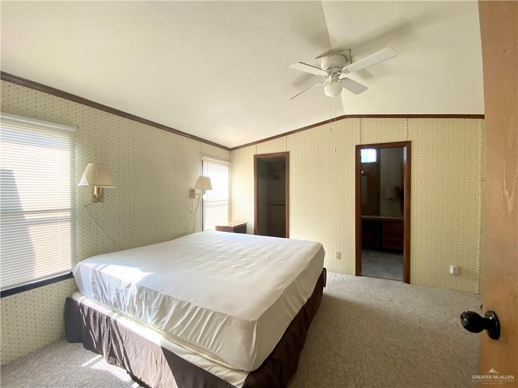 219 Bundle Wagon Drive Mission, TX 78574 - Photo 8 of 30 Bedroom featuring crown molding, carpet flooring, multiple windows, lofted ceiling, and wallpapered walls