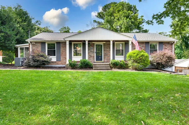 a front view of a house with a yard and green space