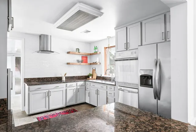 a kitchen with white cabinets and white appliances