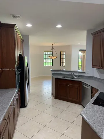 a kitchen with kitchen island a counter top space a sink and a refrigerator